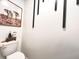 Stylish powder room with a modern toilet, unique artwork, and simple decor at 302 Bay Village Pl, Henderson, NV 89011