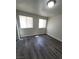 A bedroom with two large windows allowing for plenty of natural light and wood laminate flooring at 3412 Townhouse Dr, Las Vegas, NV 89121