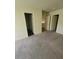 A neutral-toned bedroom featuring carpeted floors and multiple doorways at 3412 Townhouse Dr, Las Vegas, NV 89121