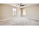 Bright bedroom with gray carpet, ceiling fan, and two windows offering plenty of natural light at 3437 Visionary Bay Ave, North Las Vegas, NV 89081