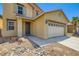 Two-story home with tan siding, desert landscaping, a two-car garage, and a tile roof at 3437 Visionary Bay Ave, North Las Vegas, NV 89081