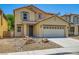 Two-story home with tan siding, desert landscaping, a two-car garage, and a tile roof at 3437 Visionary Bay Ave, North Las Vegas, NV 89081