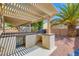Outdoor kitchen with built in grill, bar, and rock landscape at 3437 Visionary Bay Ave, North Las Vegas, NV 89081