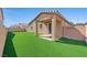 Large backyard featuring an artificial turf lawn, covered patio, and block wall perimeter at 3708 Fuselier Dr, North Las Vegas, NV 89032