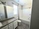 Bright bathroom featuring a shower-tub combo, gray tile flooring, and vanity with granite countertops at 3708 Fuselier Dr, North Las Vegas, NV 89032