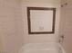 White tiled bathtub and walls feature a brown mosaic-framed inset, adding a touch of elegance to the bathroom at 4300 N Lamont St # 232, Las Vegas, NV 89115