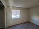 This bedroom has carpet flooring, neutral walls, and a window with blinds for natural light at 4300 N Lamont St # 232, Las Vegas, NV 89115