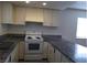 Bright kitchen with white cabinetry, granite counters, and a white range at 4451 Rich Dr # D, Las Vegas, NV 89102