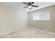 A cozy bedroom featuring a ceiling fan, neutral walls, and tile flooring at 4676 E Alexander Rd, Las Vegas, NV 89115