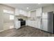 Well-lit kitchen featuring stainless steel appliances, white cabinets, and wood-look flooring at 4676 E Alexander Rd, Las Vegas, NV 89115