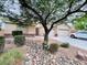 Inviting home with mature tree, rock features in the landscape, and a two-car garage at 4717 Mohawk River Ave, North Las Vegas, NV 89031