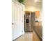 Stainless steel refrigerator in the kitchen with wooden cabinets and granite countertops near a white door at 4717 Mohawk River Ave, North Las Vegas, NV 89031