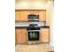 Close up of stainless steel oven and microwave in the kitchen with tiled floors and wooden cabinets at 4717 Mohawk River Ave, North Las Vegas, NV 89031