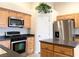 Bright kitchen featuring wooden cabinets, granite countertops, stainless steel appliances, and functional center island at 4717 Mohawk River Ave, North Las Vegas, NV 89031