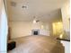 Large, carpeted living room featuring a fireplace, ceiling fan, and access to the stairs and kitchen at 4717 Mohawk River Ave, North Las Vegas, NV 89031