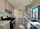 Open-concept kitchen with stainless steel appliances, mosaic backsplash, and hardwood floors leads to a bright living area at 4805 Nara Vista Way # 203, Las Vegas, NV 89103