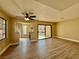 Bright living room with wood floors, ceiling fan, and sliding glass doors to a patio with a community view at 4805 Nara Vista Way # 203, Las Vegas, NV 89103