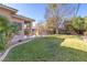A serene backyard with lush green grass, mature landscaping, and a well-maintained lawn at 5193 N Miller Ln, Las Vegas, NV 89149