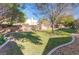 The expansive backyard has lush lawn, mature trees and defined stone border at 5193 N Miller Ln, Las Vegas, NV 89149
