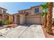 Traditional two-story home with a two-car garage, desert landscaping and palm trees at 5402 Shady Lair Ct, North Las Vegas, NV 89031