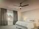 Comfortable main bedroom featuring neutral colors, a ceiling fan, and large windows for natural light at 5888 Becklow Gardens Ave, Las Vegas, NV 89141