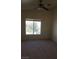 A bedroom with a window that provides a view and a ceiling fan with a light at 5969 High Steed St # 101, Henderson, NV 89011