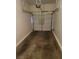Garage of townhome including a garage door opening mechanism and a bare, cracked floor at 5969 High Steed St # 101, Henderson, NV 89011