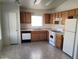 Full view of kitchen featuring oak cabinets, white appliances, and tile floors at 5969 High Steed St # 101, Henderson, NV 89011