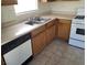 Functional kitchen featuring wood cabinets, a stainless steel sink, and modern appliances at 5969 High Steed St # 101, Henderson, NV 89011