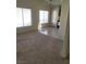 Open floor plan of living area with windows, neutral walls and flooring and kitchen area at 5969 High Steed St # 101, Henderson, NV 89011