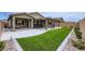 Spacious backyard features a lush lawn and covered patio, perfect for entertaining at 6519 Summershade St, North Las Vegas, NV 89086