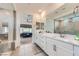 Bathroom showcasing a double vanity with white cabinetry, a sleek mirror, and a glass-enclosed walk-in shower at 6519 Summershade St, North Las Vegas, NV 89086
