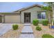 Inviting home exterior with neat landscaping, a paved walkway leading to the front door, and a two-car garage at 6519 Summershade St, North Las Vegas, NV 89086