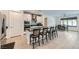 Modern kitchen with a large island with seating, stainless steel appliances, white cabinets, and an open dining area at 6519 Summershade St, North Las Vegas, NV 89086