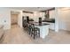 Bright kitchen with a large island with seating, stainless steel appliances, and an open view of the living area at 6519 Summershade St, North Las Vegas, NV 89086