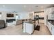 Open concept kitchen with island seating, stainless steel appliances, and a seamless transition to the living space at 6519 Summershade St, North Las Vegas, NV 89086