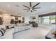 Open concept living space featuring tile floors, a large sectional sofa and a view of the kitchen and dining area at 6519 Summershade St, North Las Vegas, NV 89086