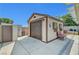 Backyard shed with a garage door and charming outdoor seating area, adding functionality and style at 6647 Montezuma Castle Ln, North Las Vegas, NV 89084