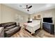 Cozy bedroom with a ceiling fan, window with shutters, and a comfortable sitting area at 6647 Montezuma Castle Ln, North Las Vegas, NV 89084
