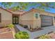 Welcoming single story home featuring a brown garage door and decorative iron screen door at 6647 Montezuma Castle Ln, North Las Vegas, NV 89084