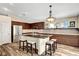 Kitchen with a large island that features dark cabinets, tile backsplash and stainless steel appliances at 6647 Montezuma Castle Ln, North Las Vegas, NV 89084