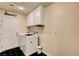 Well-lit laundry room with washer, dryer, and storage cabinets, featuring stylish geometric flooring at 6647 Montezuma Castle Ln, North Las Vegas, NV 89084