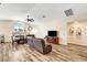 Open concept living room with laminate wood flooring, a ceiling fan, and a fireplace at 6647 Montezuma Castle Ln, North Las Vegas, NV 89084