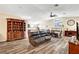 Open concept living room with laminate wood flooring, a ceiling fan, and a fireplace at 6647 Montezuma Castle Ln, North Las Vegas, NV 89084