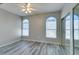 Bedroom featuring wood-look flooring, arched windows, and ceiling fan at 700 Carnegie St # 122, Henderson, NV 89052