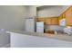Kitchen with wood cabinets, white appliances, and tile flooring at 700 Carnegie St # 122, Henderson, NV 89052