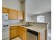 Kitchen with stainless dishwasher, double sinks, and wood cabinets at 700 Carnegie St # 122, Henderson, NV 89052