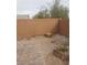 Fenced backyard with a paved brick section and natural rock, blending leisure with nature at 7112 Whitford St, Las Vegas, NV 89166