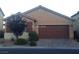 Single-story house featuring a two-car garage, neutral stucco exterior, complemented by a tile roof, and xeriscaped front yard at 7112 Whitford St, Las Vegas, NV 89166