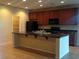 Modern kitchen with dark wood cabinets, granite countertops, stainless steel appliances, and island at 7112 Whitford St, Las Vegas, NV 89166